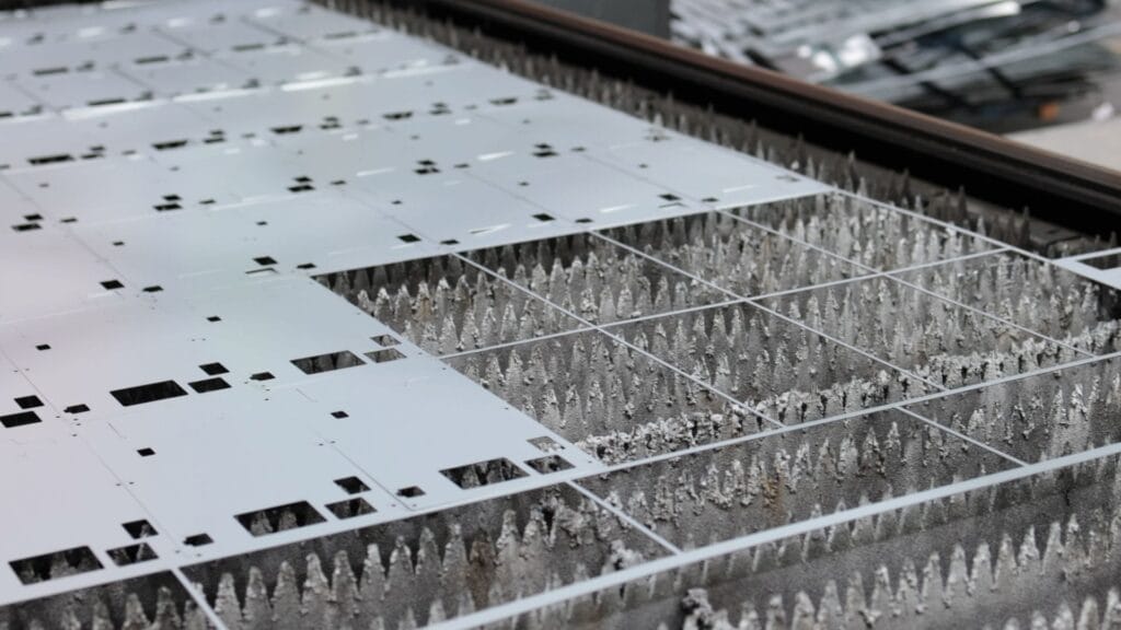 laser cut steel sheet nested parts on cutting bed.jpg